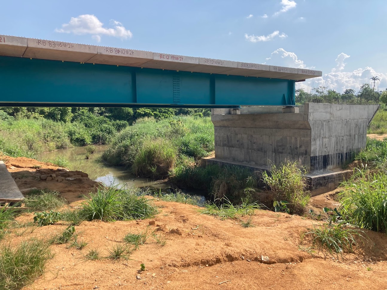 Completed modular steel bridge with concrete abutment over river crossing in Ghana — scour and erosion protection engineering