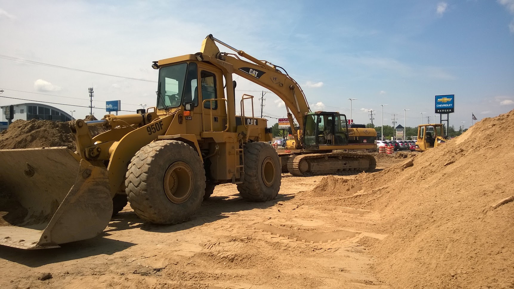 CAT wheel loader and excavator on large earthwork excavation site for stormwater detention and civil infrastructure project