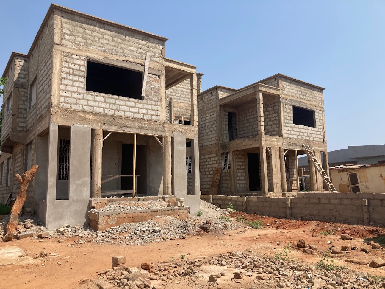Two-storey residential building under construction with reinforced concrete frame and masonry block walls in Accra, Ghana
