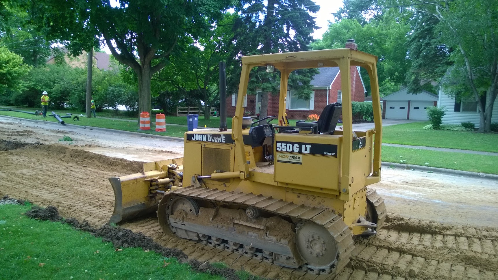 John Deere bulldozer performing road earthwork grading on a civil engineering project — earthwork design and construction supervision